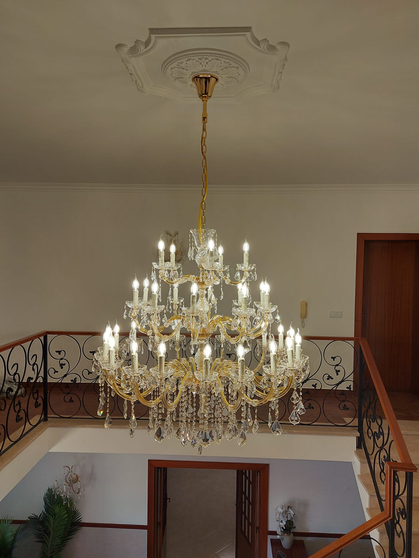 Crystal chandelier above wrought iron balustrade